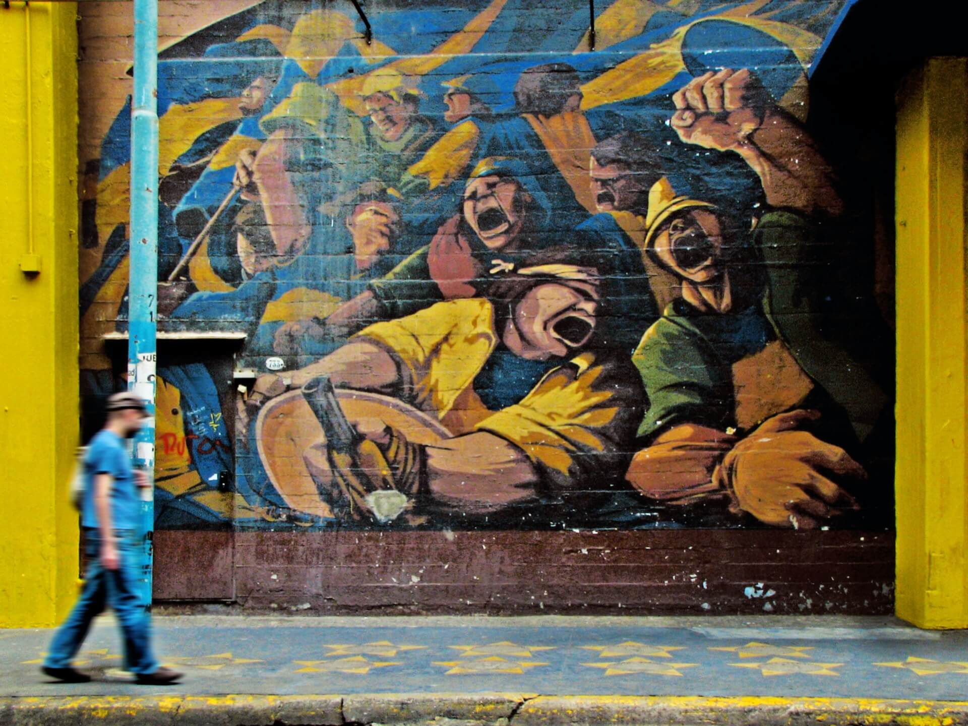 Man walking beside graffiti artwork
